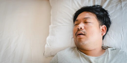 asian man sleeping on bed